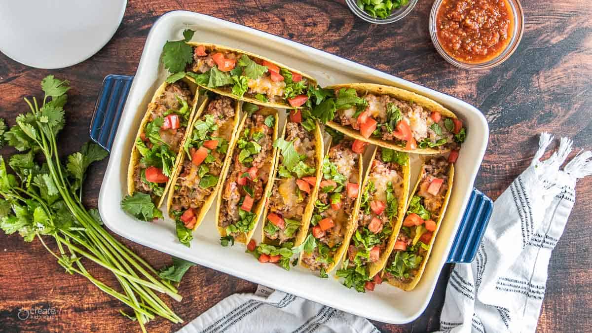 oven baked tacos with toppings in baking dish