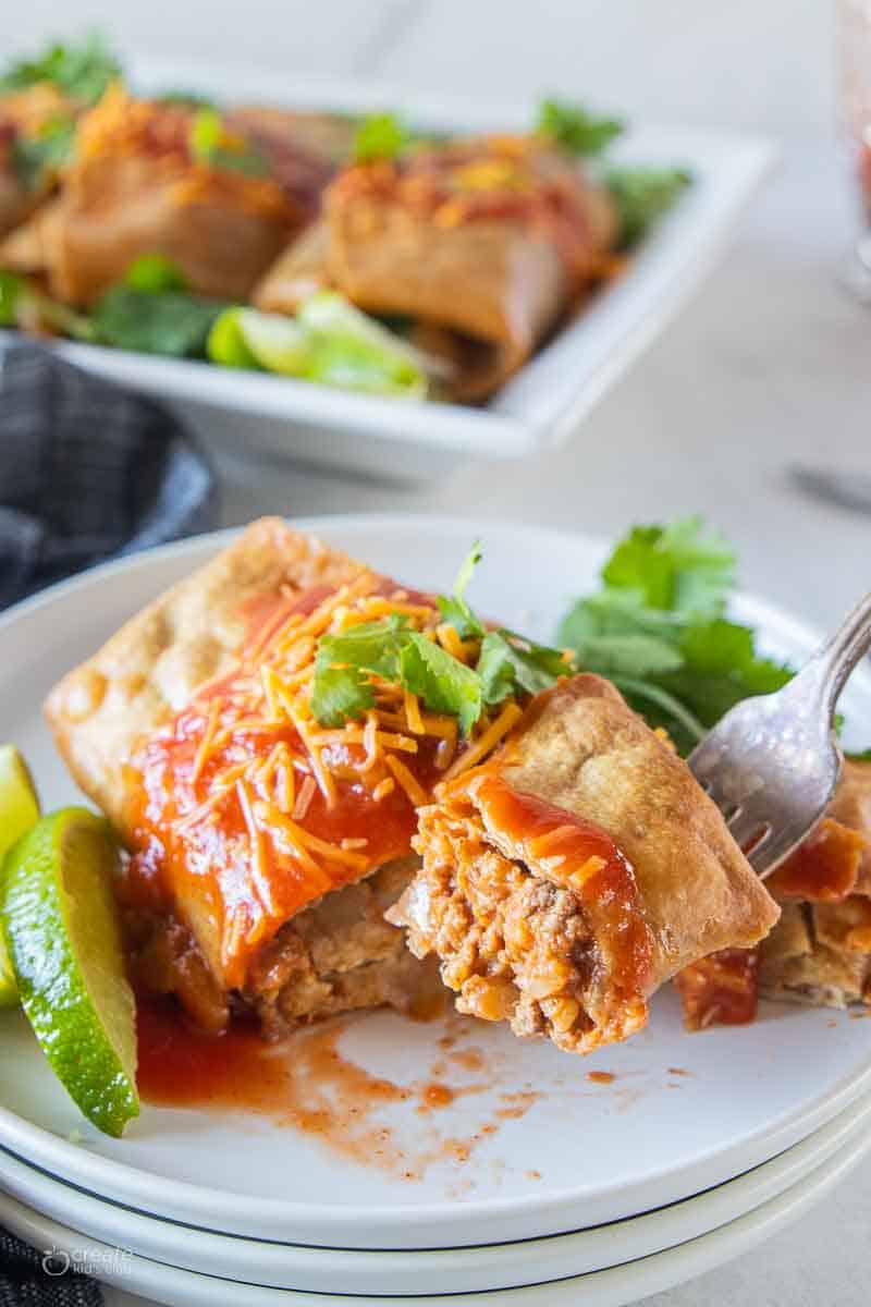 fork scooping beef chimichangas from plate