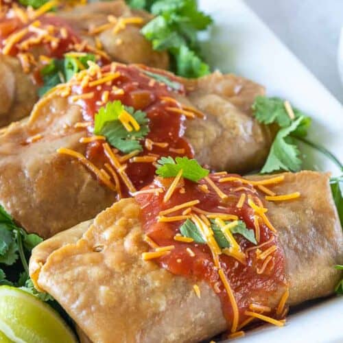 side view of beef chimichangas on white platter