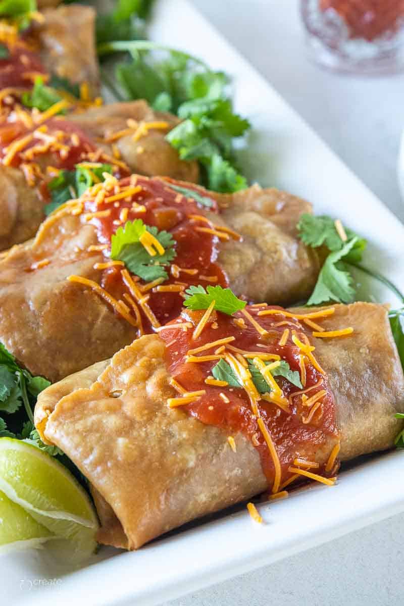 side view of beef chimichangas on white platter