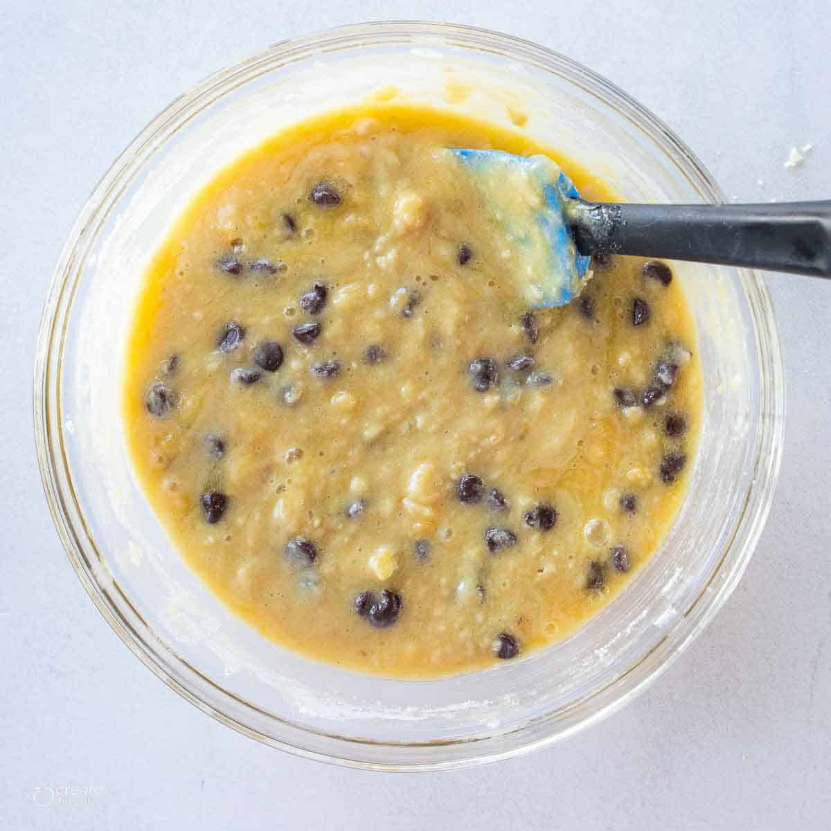 chocolate chip banana muffin batter in bowl with spatula