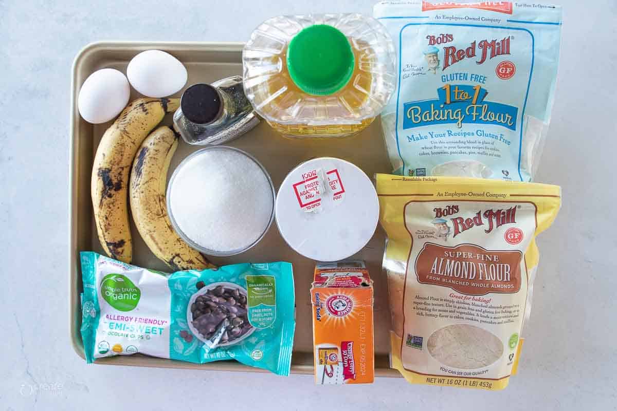 ingredients for gluten free chocolate chip banana muffins on sheet pan