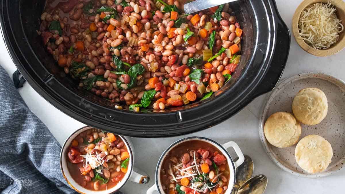 topdown view of minestrone soup in bowls next to rolls