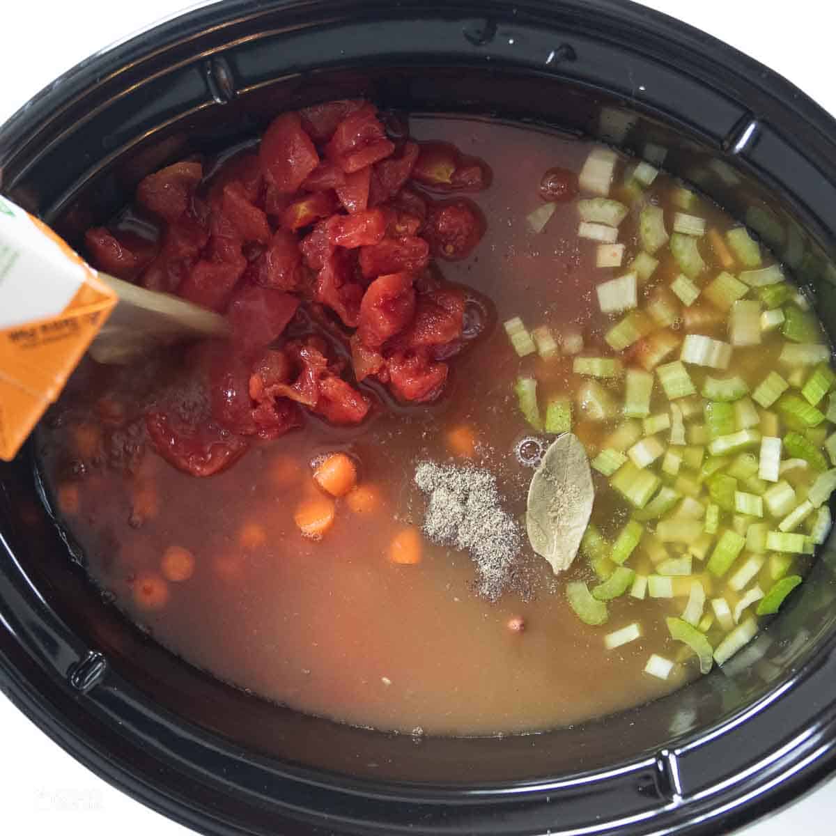 broth poured into crockpot on top of vegetables and beans