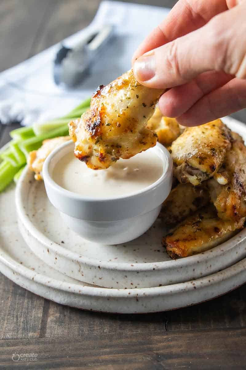 chicken wing dipped into dairy free ranch dressing