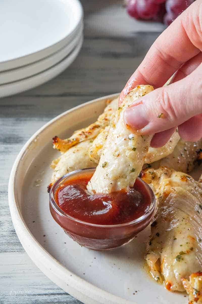 air fried chicken tender dipped into sauce