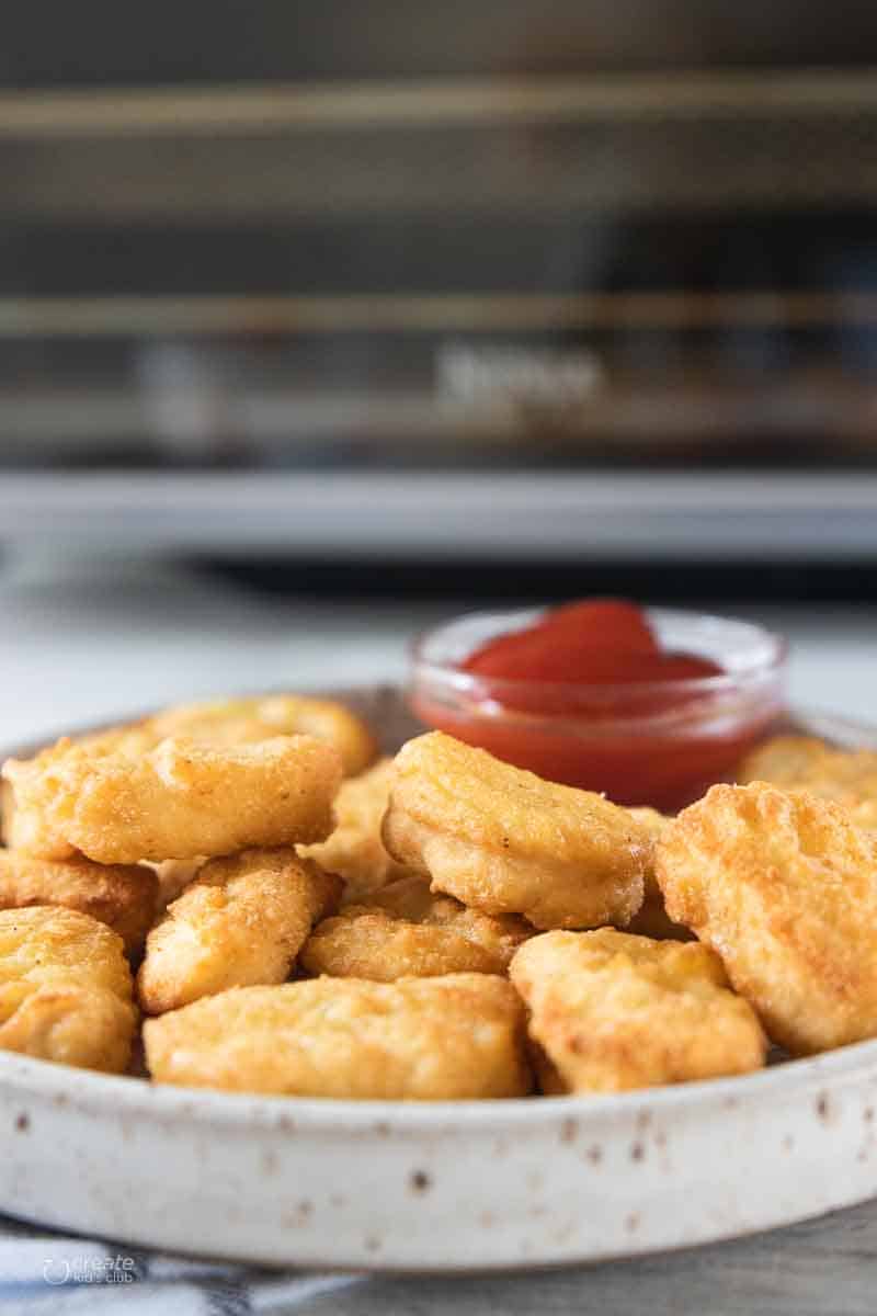 air fryer frozen chicken nuggets on plate with sauce