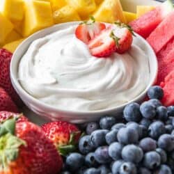 bowl of fruit dip with cool whip on platter with fruit