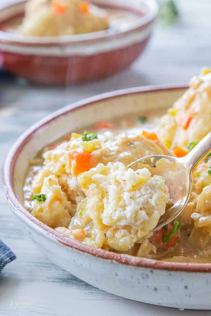 spoon scooping a bite of gluten free dumpling from soup