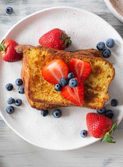 top down view of two French toast slices topped with fresh berries