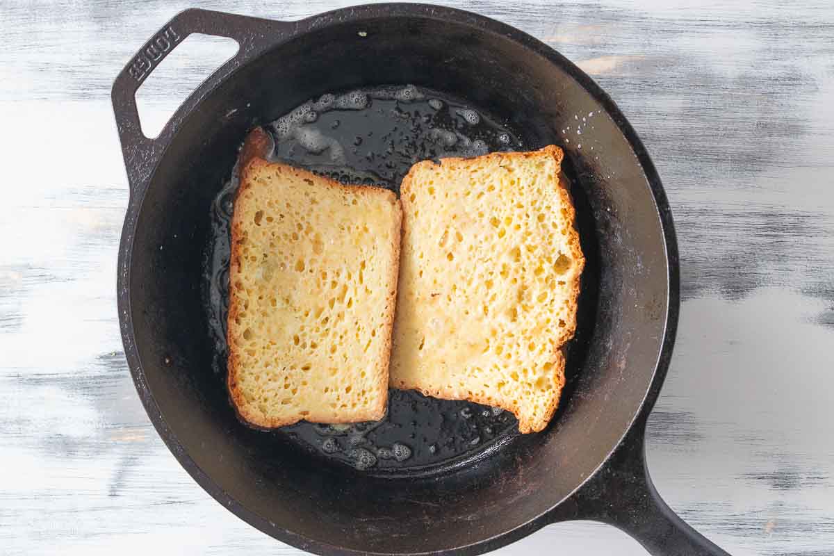 two slices of gf French toast in cast iron skillet