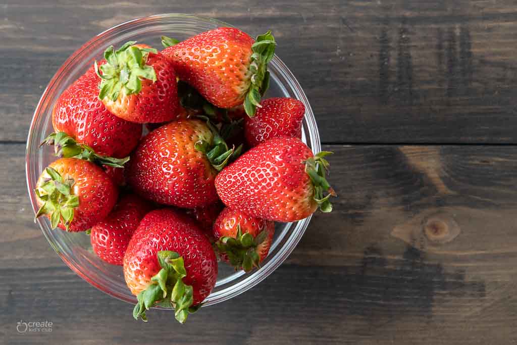 top down view of whole fresh strawberries in bowl