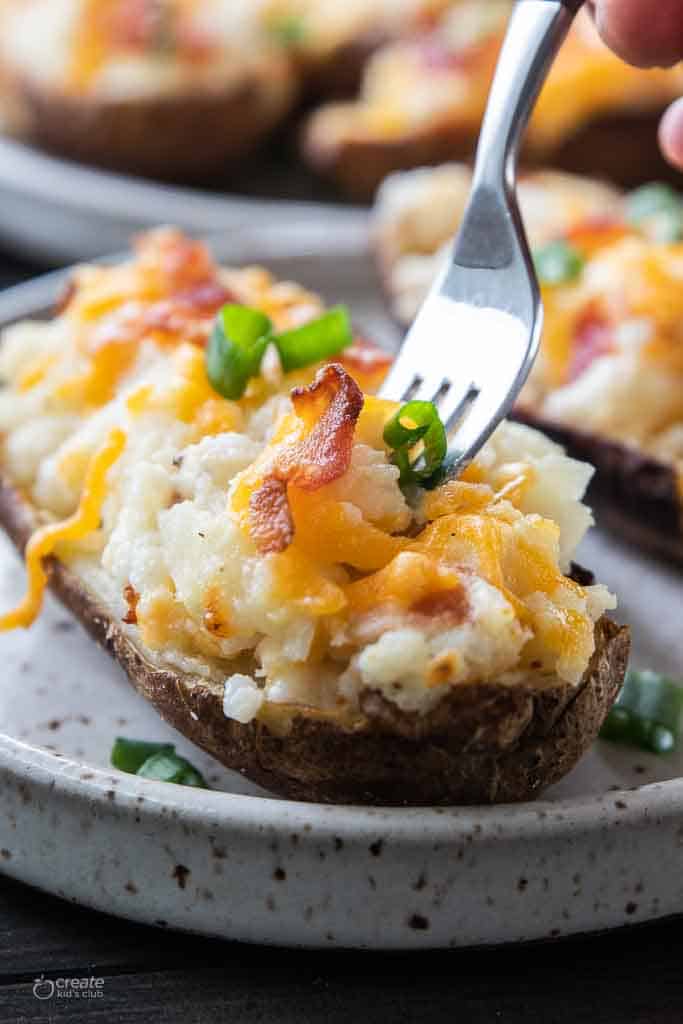 fork scooping into twice baked potato