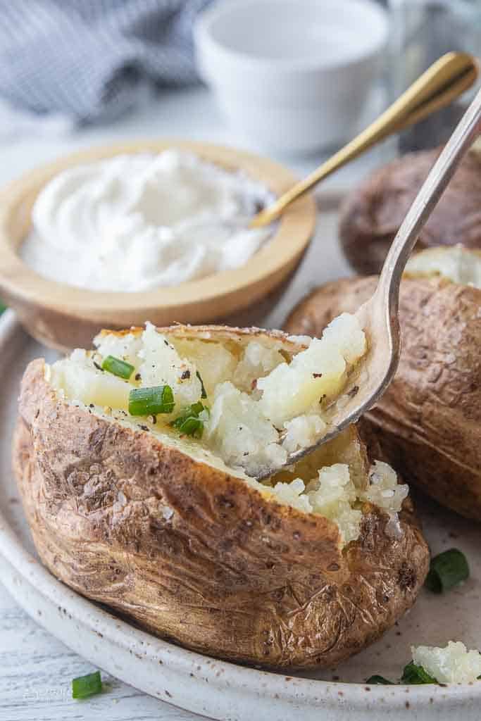 fork scooping into baked potato