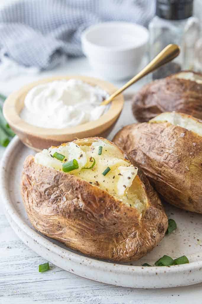 baked potato topped with better, salt, pepper and chives