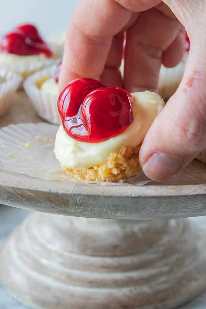 hand picking up cheesecake bite