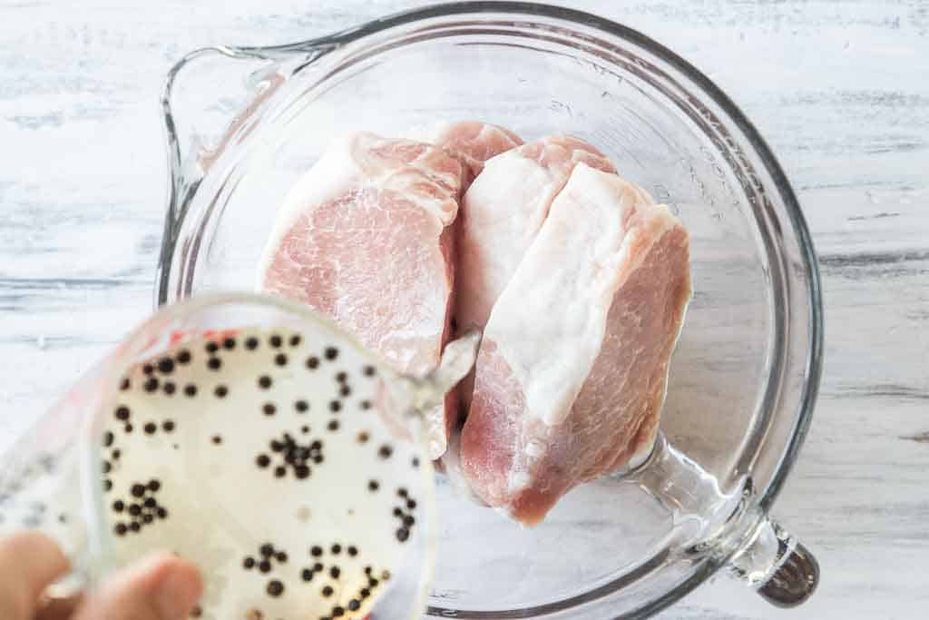 brine solution poured into bowl with pork chops