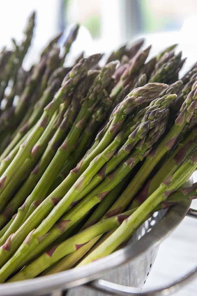 fresh asparagus in colander