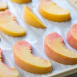 side view of peach slices on baking sheet