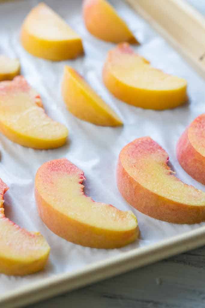 side view of peach slices on baking sheet