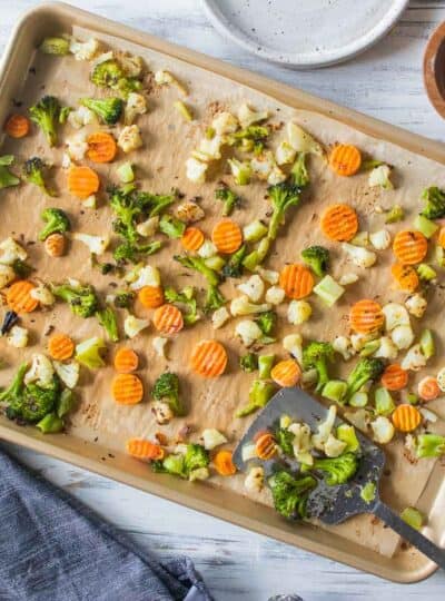 spatula scooping roasted vegetables on pan