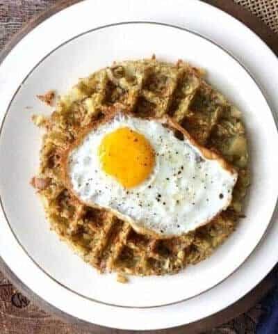 A fried egg on top of a waffle iron hash brown.