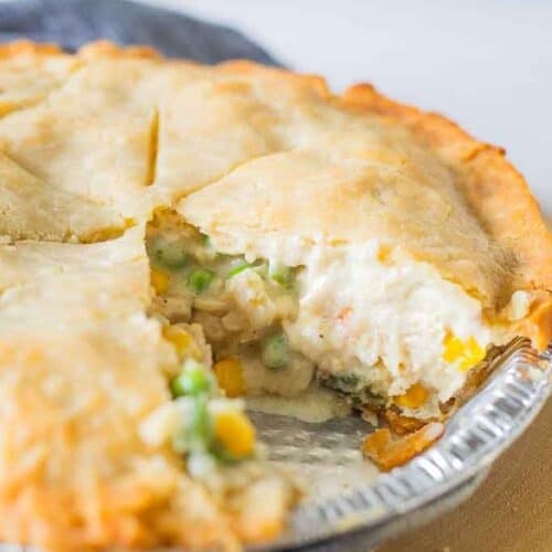 A close up shot of a gluten free chicken pot pie with a slice removed.