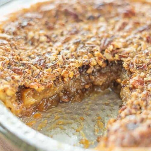 A close up view of a gluten free pecan pie with a slice removed.