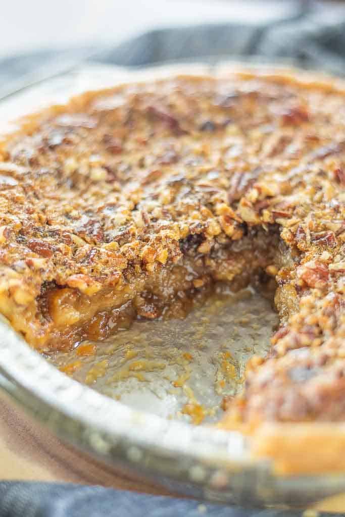 A close up view of a gluten free pecan pie with a slice removed.