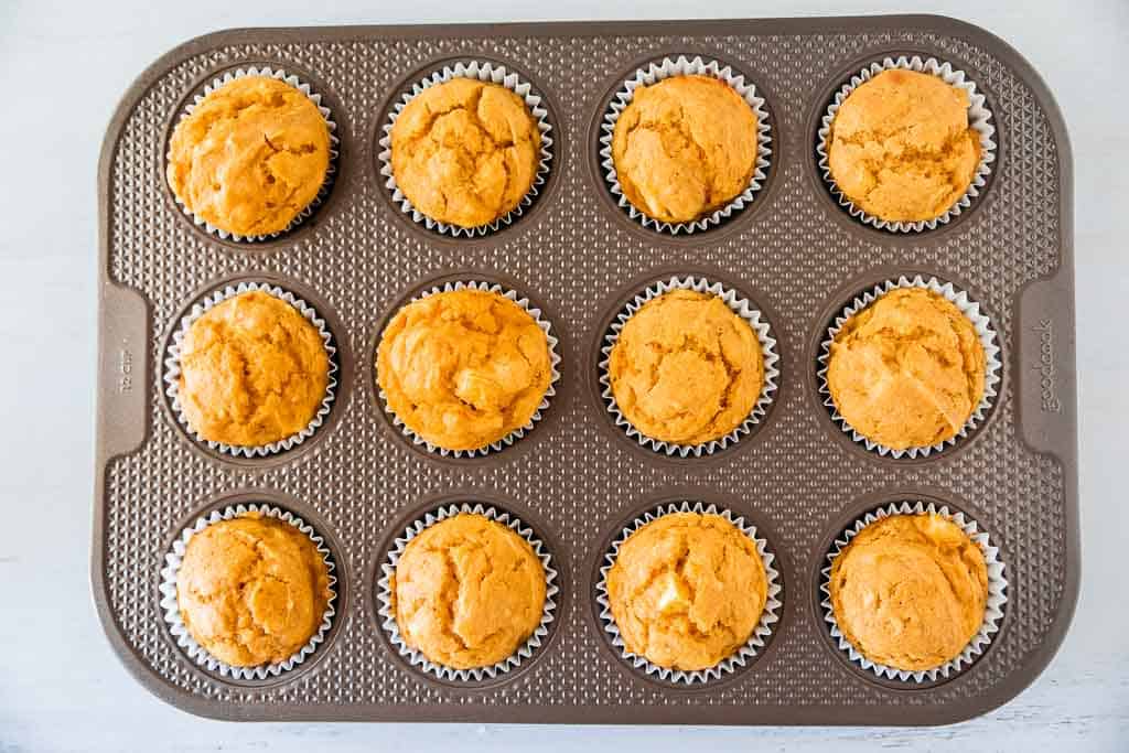 Pumpkin muffins shown in the muffin tin after baking.