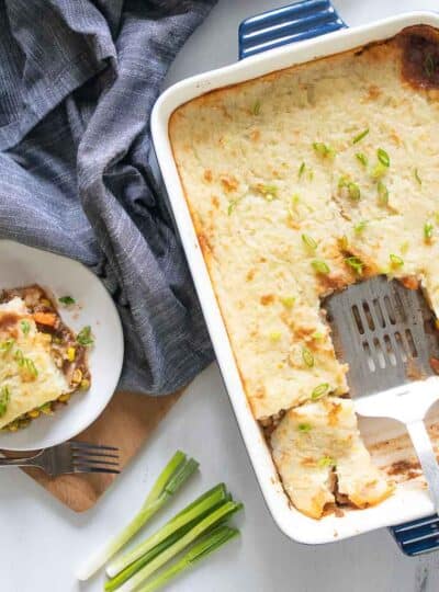 Top down pictures of a gluten free Shepards pie with a slice on a plate next to the casserole pan.