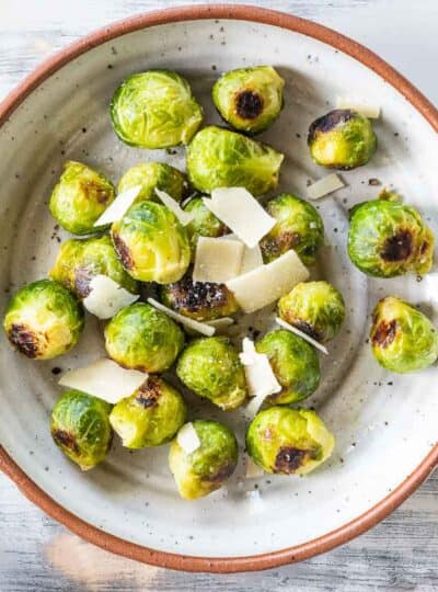 roasted brussels sprouts in a bowl topped with grated parmesan cheese