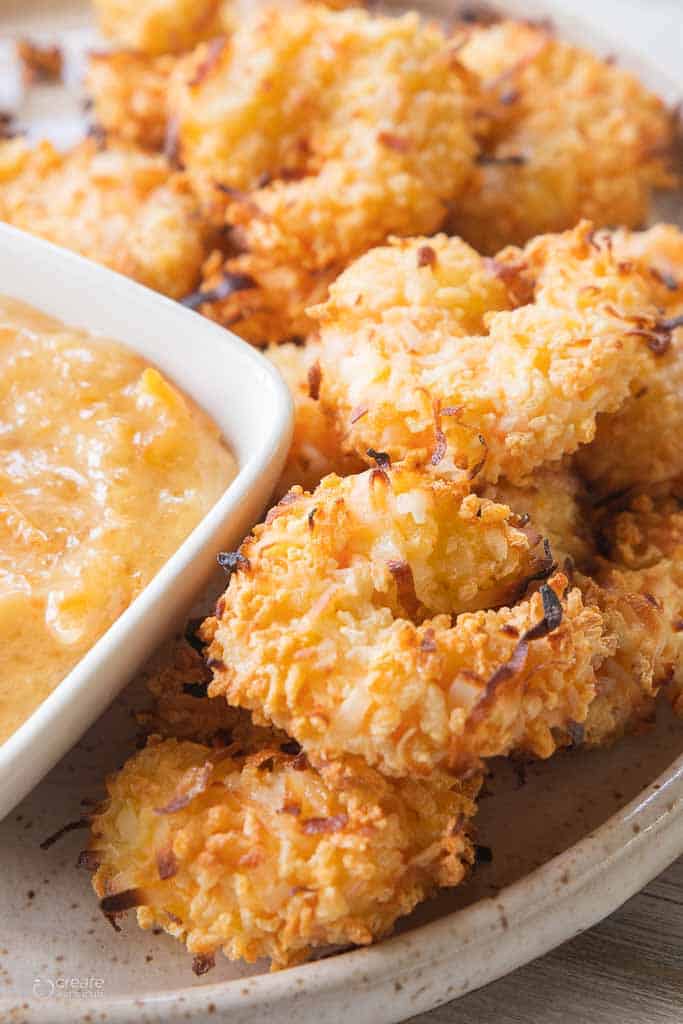 air fryer coconut shrimp on plate with dipping sauce