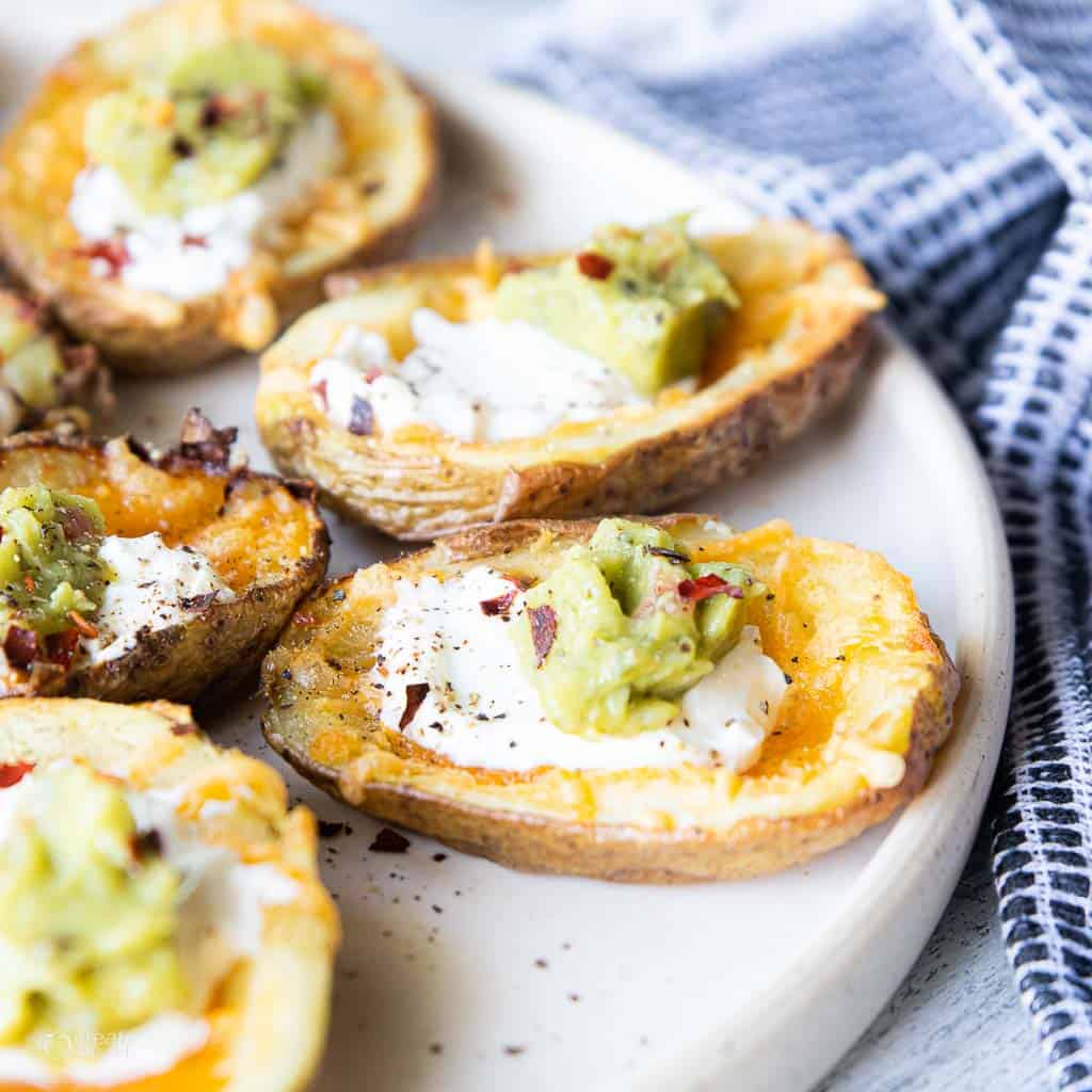 air fryer potato skins topped with cheese, sour cream and guacomole