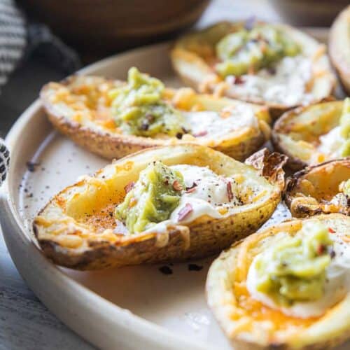 air fryer potato skins topped with cheese, sour cream and guacomole