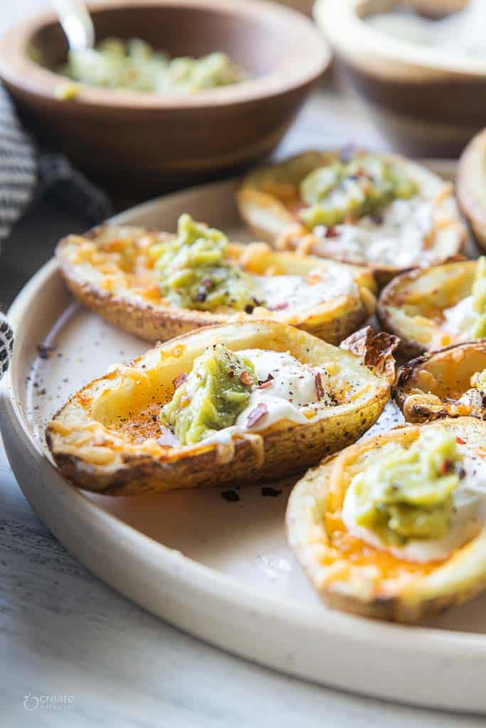 air fryer potato skins topped with cheese, sour cream and guacomole