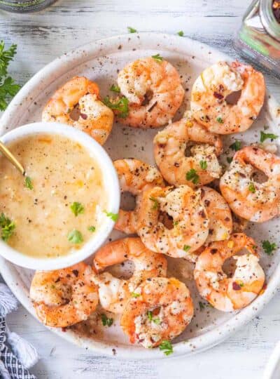 top shot of air fryer shrimp with dipping sauce on a plate