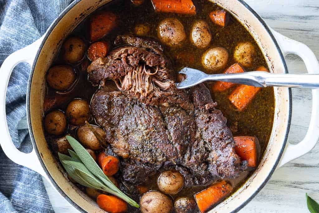 chuck roast in dutch oven pot with vegetables