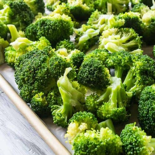 broccoli florets on parchment lined baking sheet