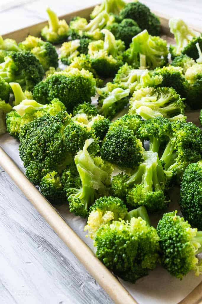 broccoli florets on parchment lined baking sheet