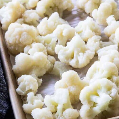 cauliflower florets on parchment lined baking sheet