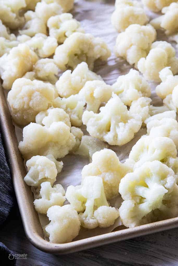 cauliflower florets on parchment lined baking sheet