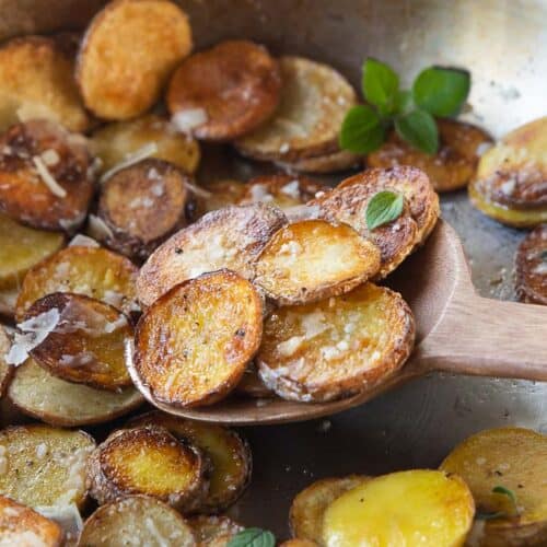 wooden spoon scooping sliced potatoes