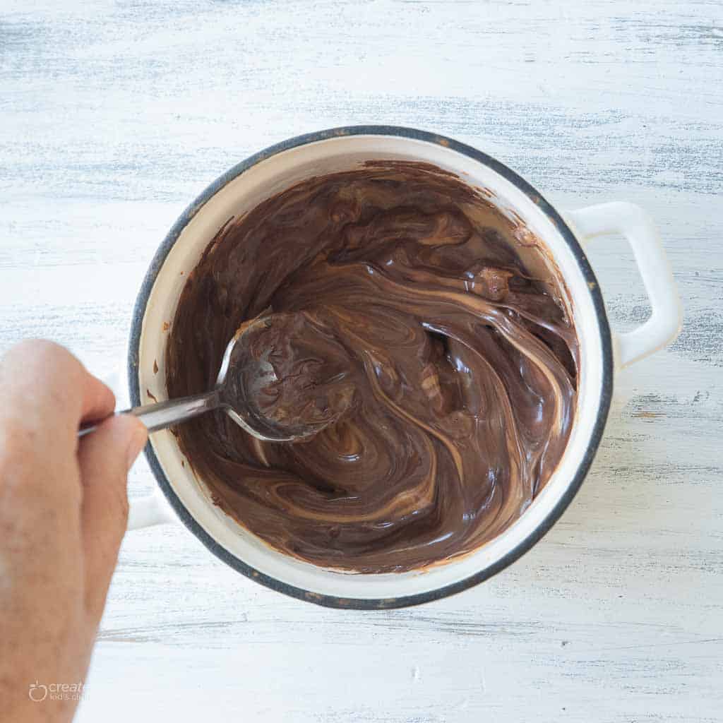 melted chocolate stirred with spoon in pot