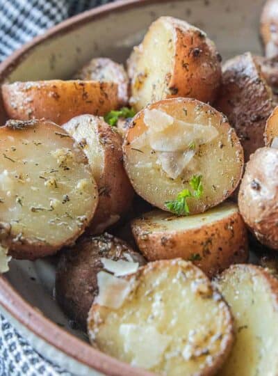 close up view of slow cooker red potatoes coated with spices and parmesan cheese