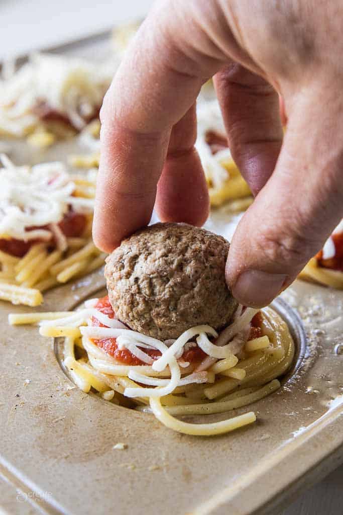 meatball placed on top of spaghetti cup