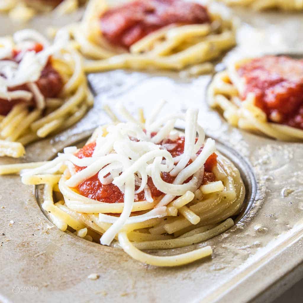 spaghetti cup topped with marinara and shredded mozzarella cheese