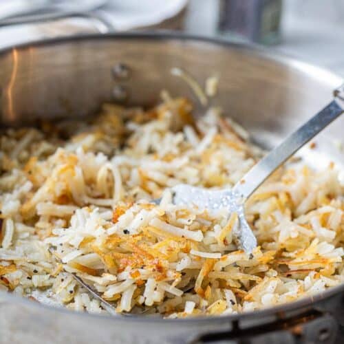 cooked hashbrowns in a skillet with spatula