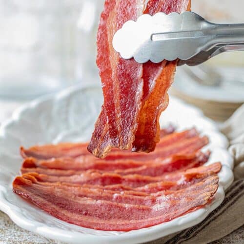 tongs picking up turkey bacon