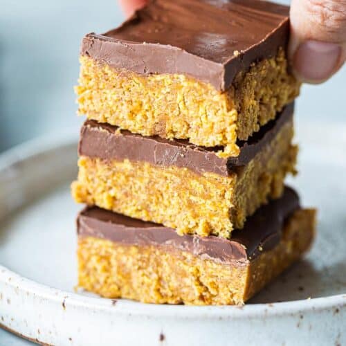A hand stacking peanut butter bars three high.